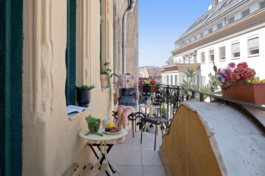 Sunny balcony breakfast nook with rooftop views over Budapest