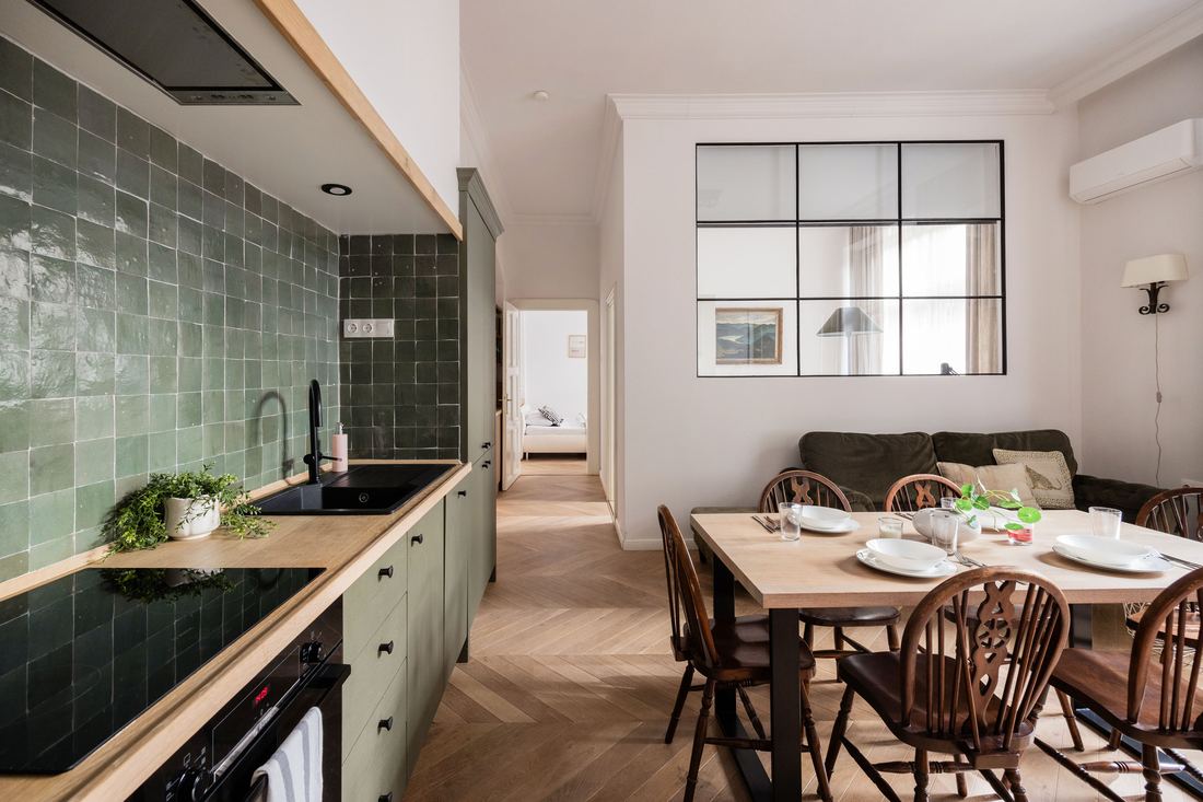 Dark green kitchen counter with the dining table set beyond